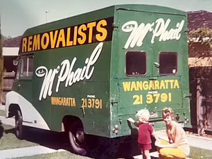 Vintage removalists van with 'McPhail' branding and two children interacting with it.